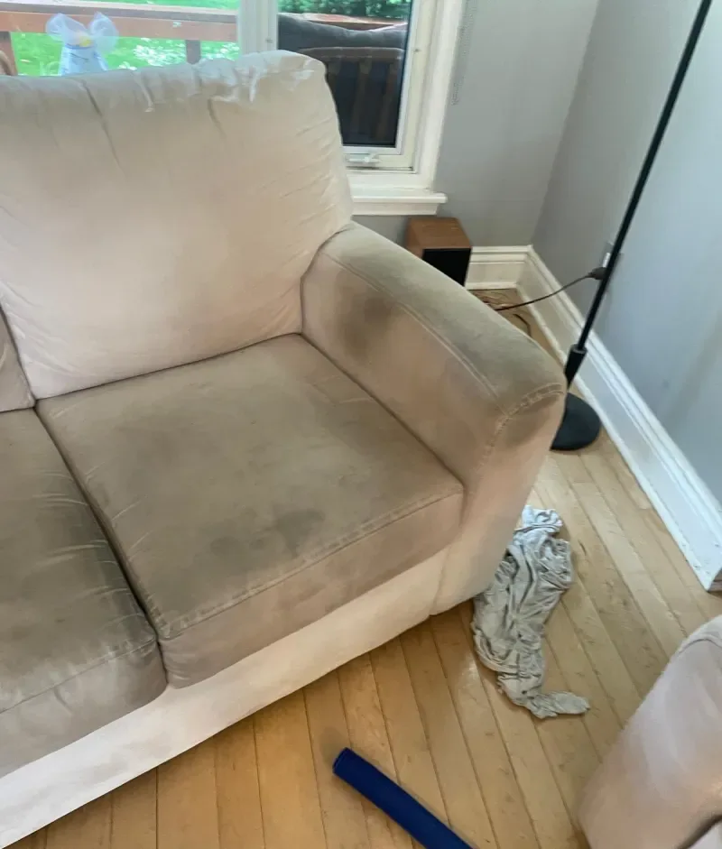 White 3-seater couch with an off-white cover showing water marks and stains before upholstery cleaning